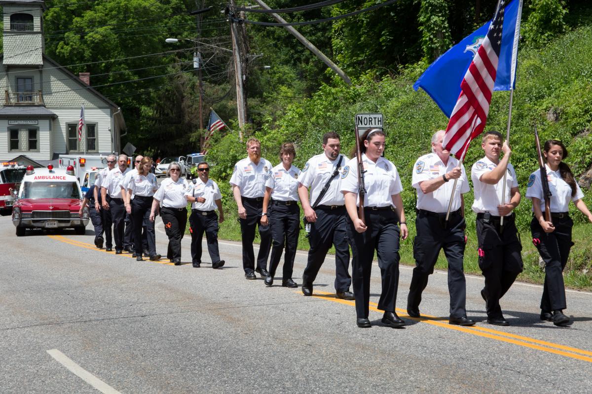 Memorial Day Parade 2016 - Men in white shirts,black pants marching in rows with American flag being carried by man in front