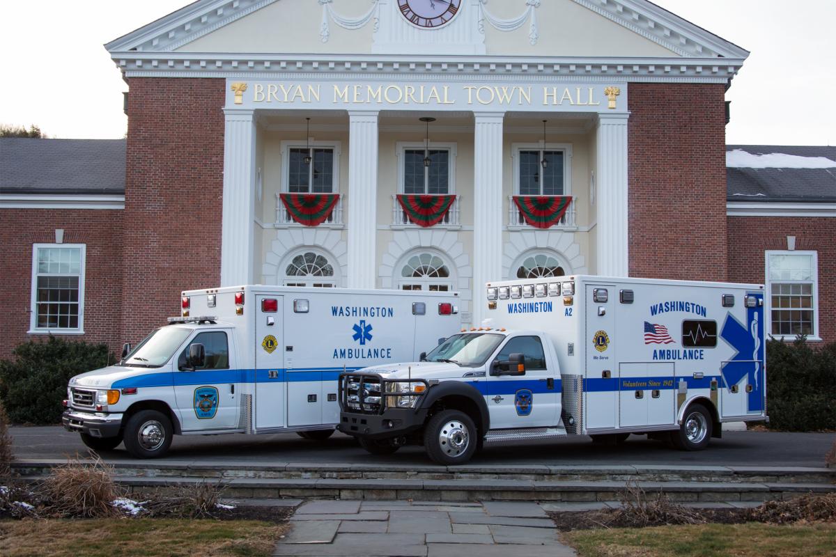 2 ambulances parked in front of town hall - building decorating with bunting