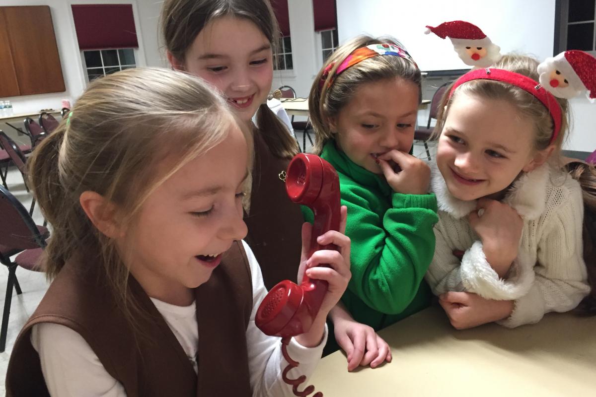 Brownie Troop #40226 visit 2016 - young girl pretending to speak into phone - 3 others laughing and smiling