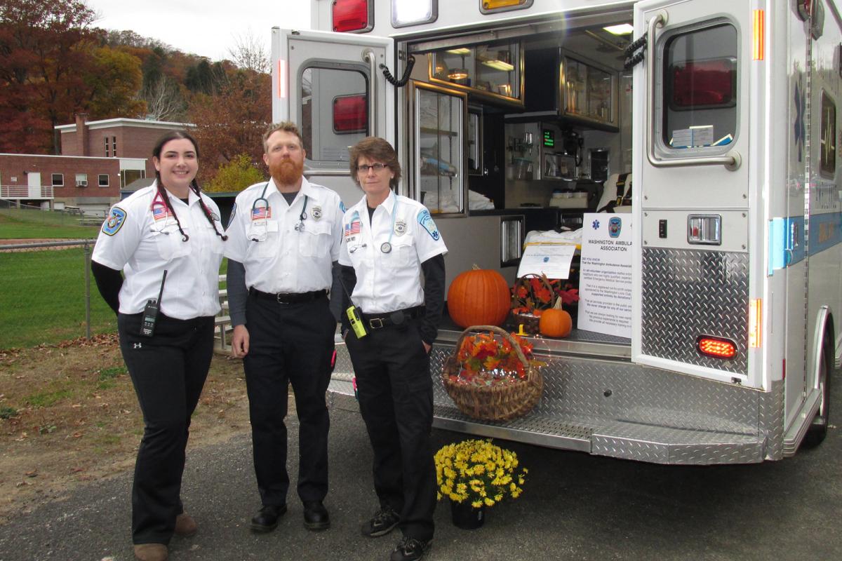 Crew at "Trunk-or-Treat" 2014 - 3 people standing facing camera behind open back doors of modern ambulance